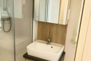 a bathroom with a white sink and a mirror at Spacious Caravan - Durdle Door Holiday Park in West Lulworth +6 photos
