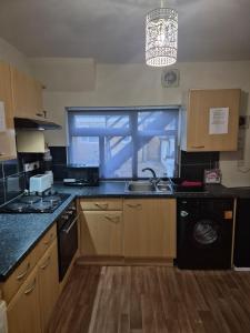 a kitchen with a sink and a washing machine at Beach Next Door Flat Retreat and Free Parking in Margate