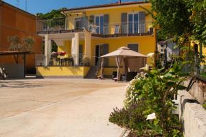 a yellow house with an umbrella in front of it at LE GEMME Bed & Breakfast con parcheggio e giardino in Casarza Ligure
