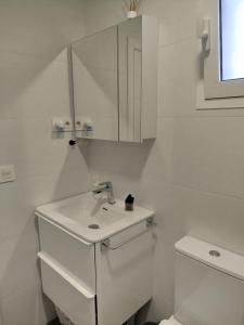 a white bathroom with a sink and a toilet at Loresti Mare in Fuengirola