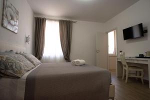 a bedroom with a bed and a desk with a computer at LE GEMME Bed & Breakfast con parcheggio e giardino in Casarza Ligure