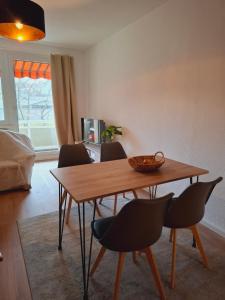a dining room table with chairs and a bowl on it at Lua Beleza - 4 Bett Apartment Geiseltalsee in Mücheln