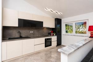 a kitchen with white cabinets and a sink at Villa LM in Krnica