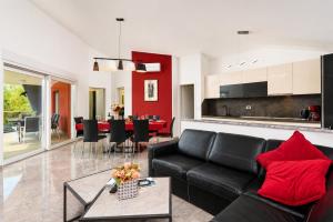 a living room with a black couch and red pillows at Villa LM in Krnica