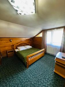 a bedroom with a large bed in a room with a window at Лісова казка in Yaremche
