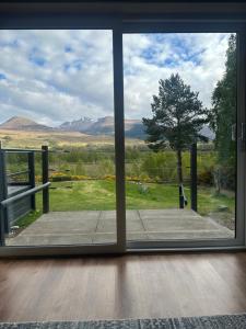 a view from a sliding glass door of a yard at Coiseag at Maol Ruadh, Roy Bridge, near Ben Nevis in Roybridge