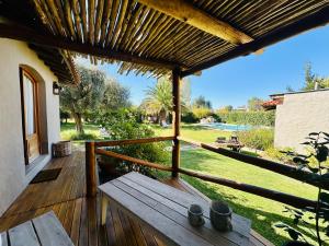 a wooden deck with a bench on a house at Casa Cayé Solar del Plata in Vistalba