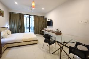 a hotel room with a bed and a glass table at MB hotel in Rajkot