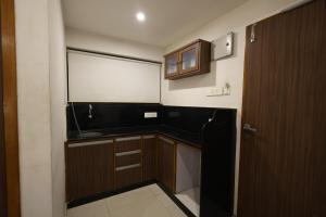 a small kitchen with a large window and a door at MB hotel in Rajkot