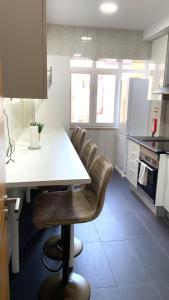 a kitchen with a white table and leather chairs at Vista Central Amadora in Amadora