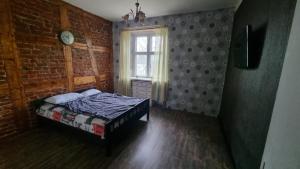 a bedroom with a bed and a brick wall at Helme mõis in Helme
