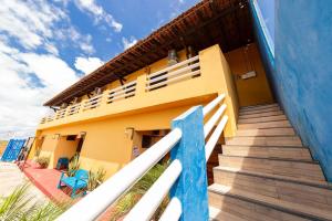 a house with stairs leading to the front of it at Pousada Costa do Mar in Luis Correia