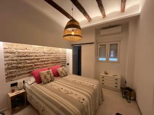 a bedroom with a bed and a brick wall at Casa Inés in Xerta