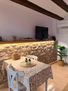 a dining room with a table and a tv on a wall at Casa Inés in Xerta