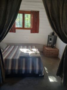 a bedroom with a bed in a room with windows at Pacha Wasi in Humahuaca