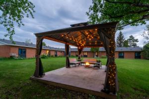 a wooden gazebo with a bench and lights at Nekinan Lodge in Smoky Lake