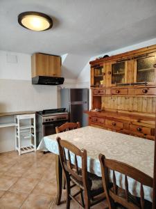 a kitchen with a table with chairs and a refrigerator at Casa Allegra in Pont-Saint-Martin