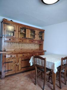 a dining room with a table and a wooden cabinet at Casa Allegra in Pont-Saint-Martin