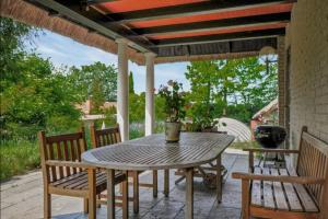 a wooden table and chairs on a patio at Skovgaardsvej 7 in Udby