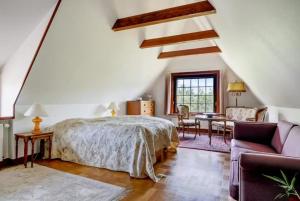 a bedroom with a bed and a couch and a table at Skovgaardsvej 7 in Udby
