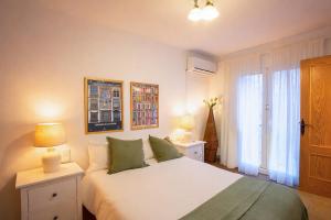 a bedroom with a bed and two lamps and a window at Bonito chalet en Valldemossa in Valldemossa +22 photos