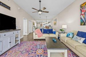 a living room with a couch and a flat screen tv at Harborview Oasis in Clearwater Beach in Clearwater Beach