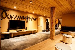 a living room with a flat screen tv on a wall at alpen select lodge Kleinwalsertal in Riezlern