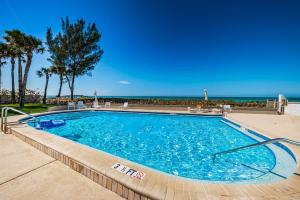 a swimming pool with the ocean in the background at Beachfront Aldea 12 in Clearwater Beach