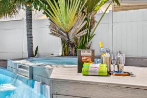 a table next to a swimming pool with a bottle of wine at Coastal Beach Retreat in Clearwater Beach +59 photos