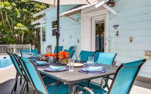 a wooden table with blue chairs on a patio at Coastal Beach Retreat in Clearwater Beach