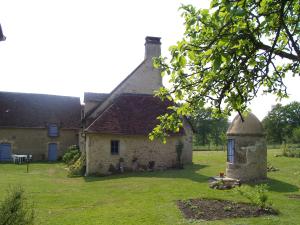 an old stone house with a tower in the yard at Maison d'Hôtes Les Après in Bellême