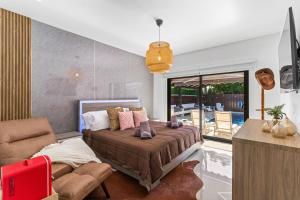 a bedroom with a bed and a couch and a table at Sunset Villa w Pool, Outdoor kitchen & Grill in Hialeah