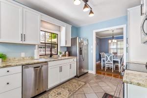 a kitchen with white cabinets and a dining room at Coconut Beach House in Clearwater Beach
