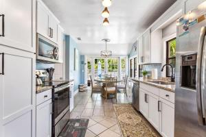a kitchen with white cabinets and a dining room at Coconut Beach House in Clearwater Beach