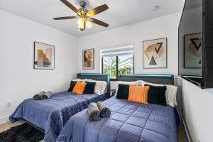 a bedroom with two beds and a ceiling fan at Sunset Villa w Pool, Outdoor kitchen & Grill in Hialeah +50 photos