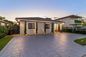 a house with a driveway in front of it at Sunset Villa w Pool, Outdoor kitchen & Grill in Hialeah