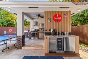 an outdoor kitchen with a ping pong table at Sunset Villa w Pool, Outdoor kitchen & Grill in Hialeah