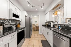 a kitchen with white cabinets and black counter tops at Sunset Beach House in Clearwater Beach