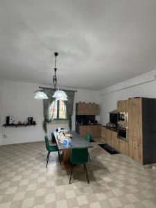 a kitchen with a table and green chairs in a room at B&B Villa Brikinnia in Lentini