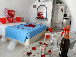 a bedroom with a bed and a table with a bottle of wine at Sofi Rooms in Fira +35 photos