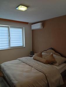 a bedroom with a white bed with a window at Vila Ziki in Sarajevo