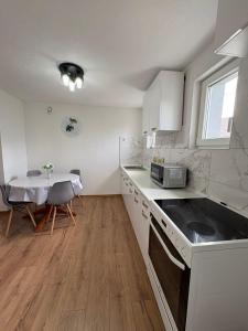 a kitchen with white cabinets and a table and a tableablish at Vila Ziki in Sarajevo