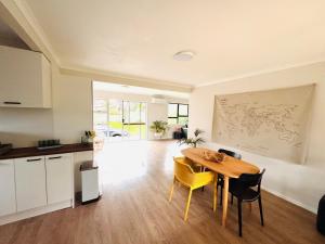 a kitchen and dining room with a table and chairs at The Bach at One Tree Point in One Tree Point