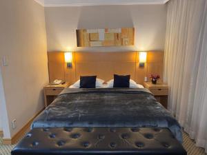a bedroom with a large bed with two night stands at Flat Guarulhos - 4 in Guarulhos +13 photos