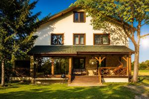 a house with a wrap around porch at Leśne Zacisze in Iława