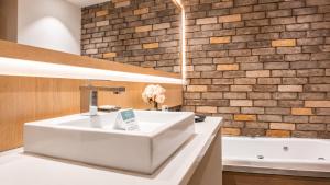 a bathroom with a white sink and a bath tub at Hotel Punto MX in Mexico City +54 photos