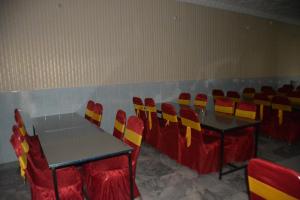 a room with two tables and chairs with red and yellow chairs at Hotel Hills City, Swat in Mingāora