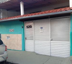 two garage doors on a building with numbers on them at Maria Hostel Brasil gru in Guarulhos