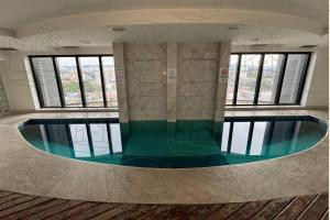 a swimming pool in a building with windows at Flat Guarulhos - 4 in Guarulhos