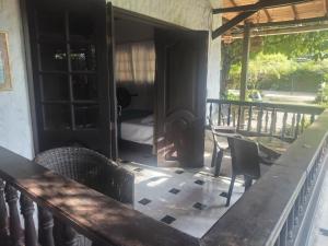 a porch with a table and chairs and a bedroom at HOSPEDAJE TURÍSTICO CAMPESTRE "VILLA ALONDRA" Parqueo Privado! in Villavicencio